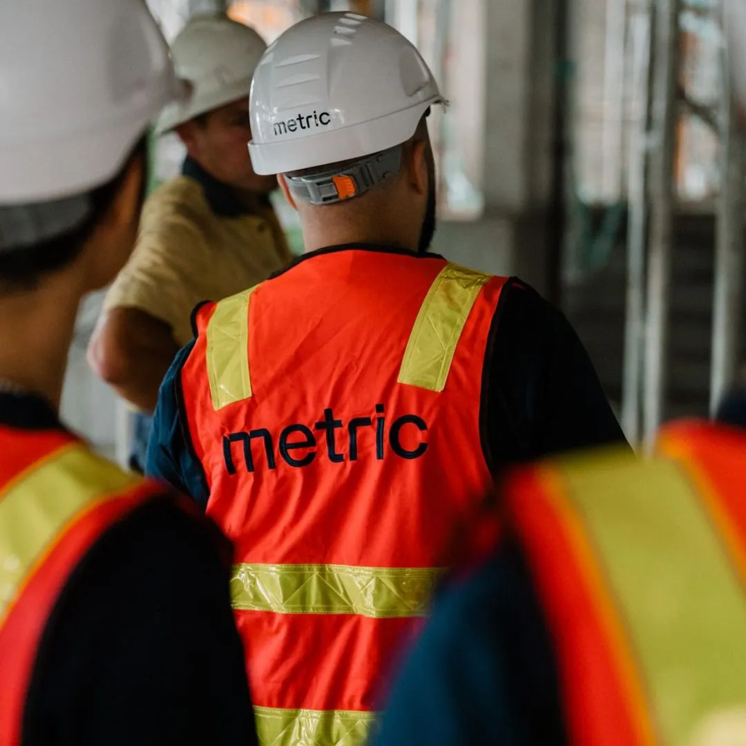 Metric engineers in hard hats and hi-vis on a construction site